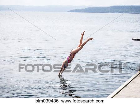 Stock Photograph - Caucasian girl diving into lake. Fotosearch
