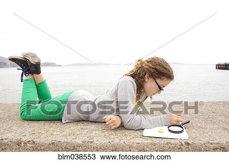 Caucasian girl doing homework on concrete wall over ocean View Large Photo Image Stock Image - Caucasian girl doing homework on concrete wall over ocean. Fotosearch