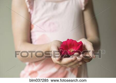 Stock Photography - Caucasian girl holding blooming flower. Fotosearch