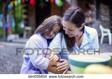 Picture - Caucasian girl hugging mother outdoors. Fotosearch