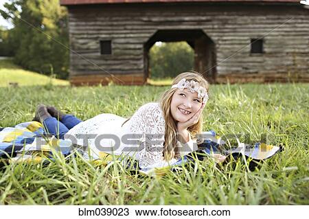 Caucasian girl laying in grass on farm View Large Photo Image Stock Image - Caucasian girl laying in grass on farm. Fotosearch