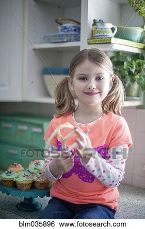 Caucasian girl licking mixing paddle in kitchen View Large Photo Image Stock Photograph - Caucasian girl licking mixing paddle in kitchen. Fotosearch