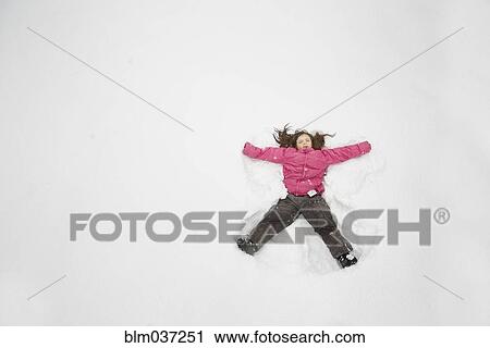 Stock Image - Caucasian girl making snow angel. Fotosearch
