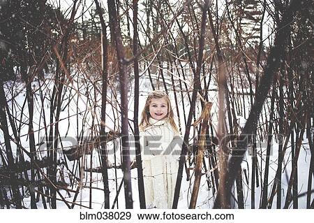 Stock Photo - Caucasian girl playing in snowy forest. Fotosearch