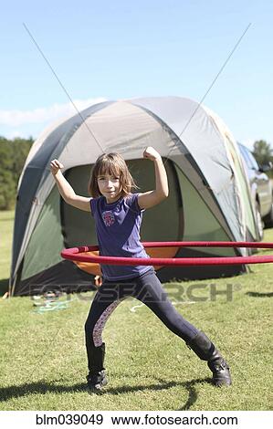 Caucasian girl playing with plastic hoop at campsite View Large Photo Image Stock Photo - Caucasian girl playing with plastic hoop at campsite. Fotosearch