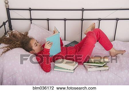 Caucasian girl reading books on bed View Large Photo Image Stock Image - Caucasian girl reading books on bed. Fotosearch