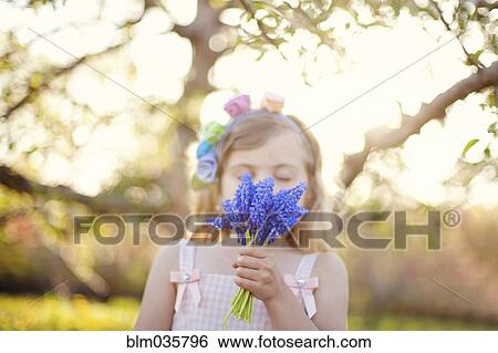 Caucasian girl smelling flowers outdoors View Large Photo Image Stock Photograph - Caucasian girl smelling flowers outdoors. Fotosearch