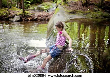 Picture - Caucasian girl splashing in river. Fotosearch