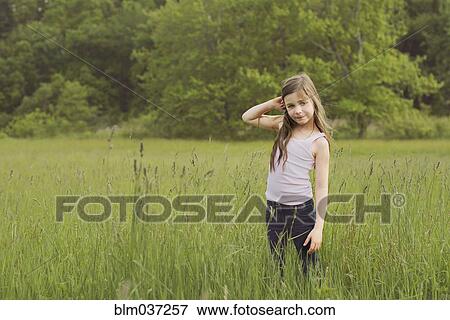 Stock Photo - Caucasian girl standing in rural field. Fotosearch