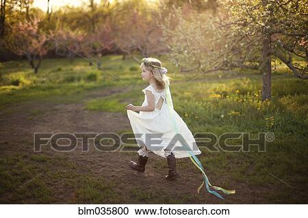 Stock Image - Caucasian girl walking on dirt path. Fotosearch