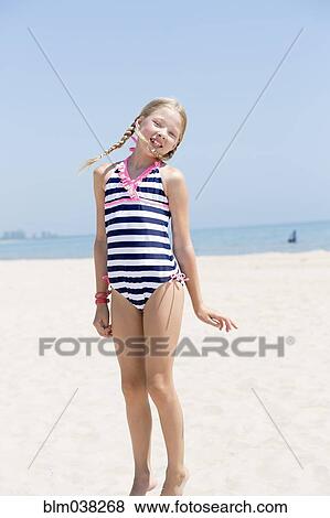 Stock Photo - Caucasian girl wearing bathing suit on beach. Fotosearch