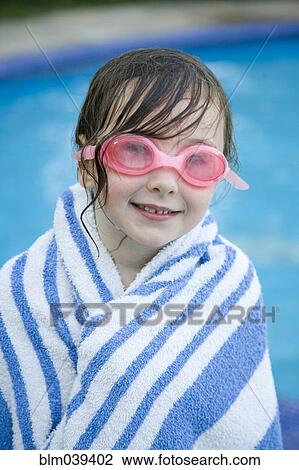 Stock Image - Caucasian girl wrapped in towel by swimming pool. Fotosearch