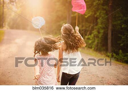 Caucasian girls carrying butterfly nets on dirt road View Large Photo Image Stock Photograph - Caucasian girls carrying butterfly nets on dirt road. Fotosearch