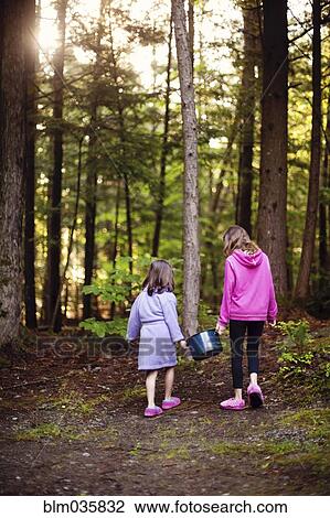 Caucasian girls carrying pot of water in forest View Large Photo Image Stock Image - Caucasian girls carrying pot of water in forest. Fotosearch
