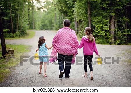 Stock Photograph - Caucasian grandmother and granddaughters on rural road. Fotosearch
