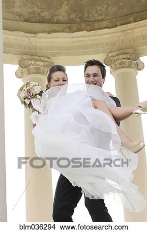 Caucasian groom carrying bride after wedding View Large Photo Image Picture - Caucasian groom carrying bride after wedding. Fotosearch