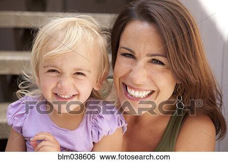 Stock Photograph - Caucasian mother and daughter smiling on steps. Fotosearch