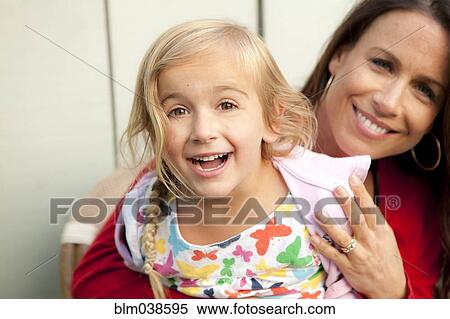 Stock Photography - Caucasian mother and daughter smiling outdoors. Fotosearch