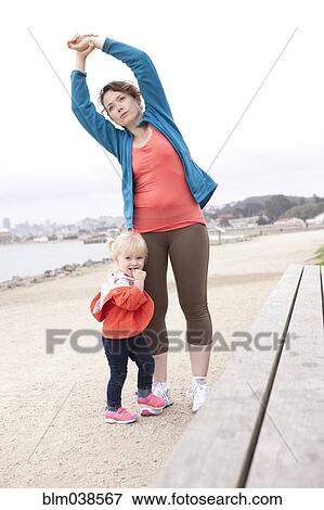Caucasian mother and daughter stretching on beach View Large Photo Image Stock Photo - Caucasian mother and daughter stretching on beach. Fotosearch
