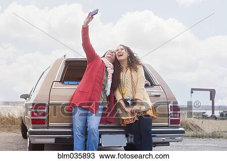 Caucasian mother and daughter taking selfie near car View Large Photo Image Stock Image - Caucasian mother and daughter taking selfie near car. Fotosearch