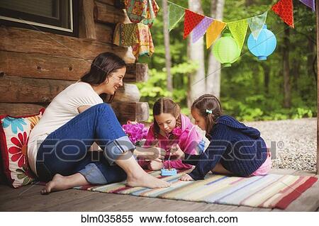Caucasian mother and daughters playing with toy on cabin porch View Large Photo Image Stock Photography - Caucasian mother and daughters playing with toy on cabin porch. Fotosearch
