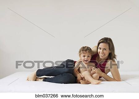 Caucasian mother and son laying on bed View Large Photo Image Stock Photograph - Caucasian mother and son laying on bed. Fotosearch