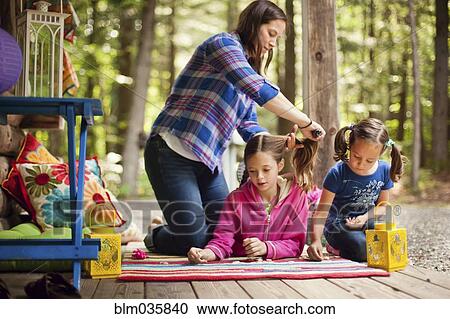 Caucasian mother brushing hair of daughter on porch View Large Photo Image Stock Image - Caucasian mother brushing hair of daughter on porch. Fotosearch