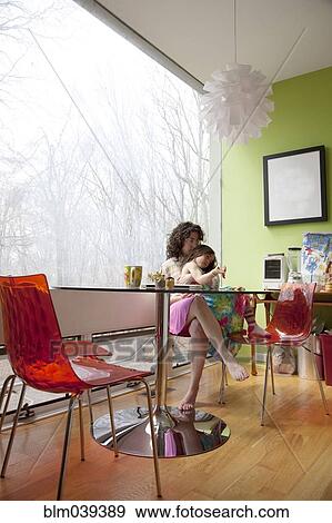Caucasian mother hugging daughter at kitchen table View Large Photo Image Stock Photo - Caucasian mother hugging daughter at kitchen table. Fotosearch