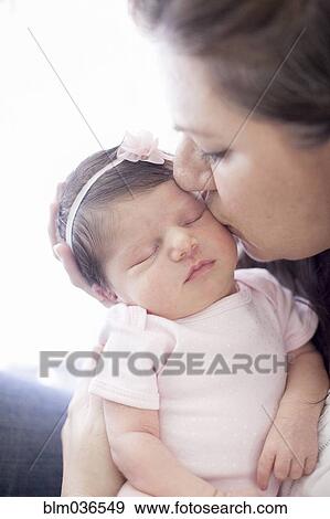 Caucasian mother kissing baby girl View Large Photo Image Stock Photo - Caucasian mother kissing baby girl. Fotosearch