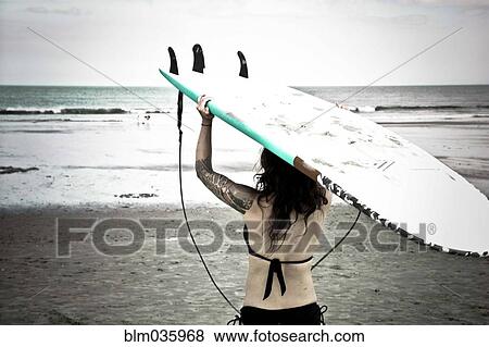 Caucasian surfer carrying surfboard on beach View Large Photo Image Stock Photo - Caucasian surfer carrying surfboard on beach. Fotosearch