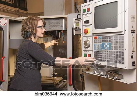 Caucasian technician operating machinery in warehouse View Large Photo Image Picture - Caucasian technician operating machinery in warehouse. Fotosearch