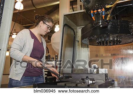 Stock Photography - Caucasian technician operating machinery in warehouse. Fotosearch