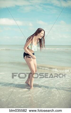 Caucasian teenage girl playing in waves on beach View Large Photo Image Stock Image - Caucasian teenage girl playing in waves on beach. Fotosearch