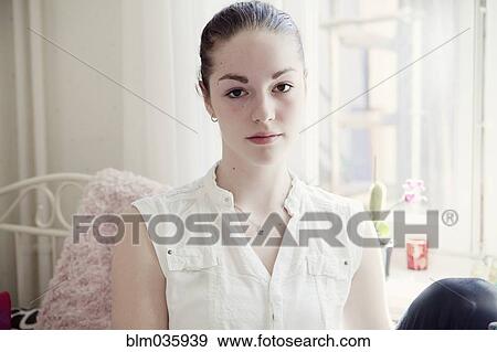 Caucasian teenage girl sitting on bed View Large Photo Image Stock Photo - Caucasian teenage girl sitting on bed. Fotosearch
