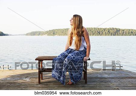 Caucasian teenage girl sitting on wooden dock at lake View Large Photo Image Picture - Caucasian teenage girl sitting on wooden dock at lake. Fotosearch
