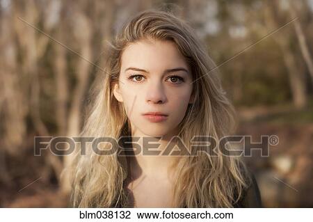 Stock Image - Caucasian teenage girl standing in park. Fotosearch