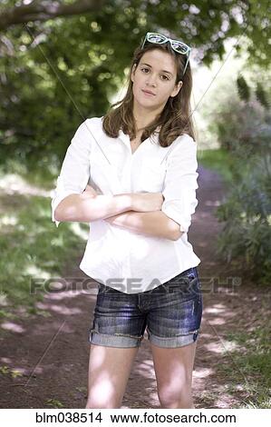 Picture - Caucasian teenage girl standing on dirt path. Fotosearch