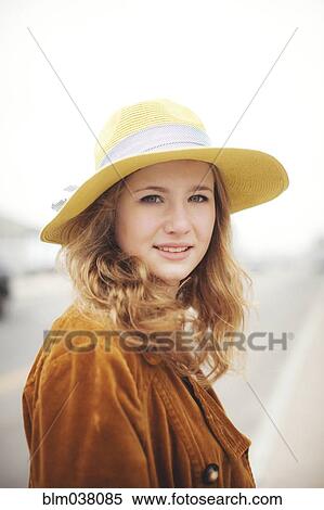 Stock Photography - Caucasian teenage girl wearing sun hat outdoors. Fotosearch