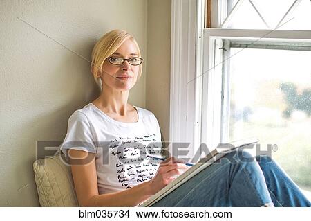 Caucasian woman drawing in windowsill View Large Photo Image Picture - Caucasian woman drawing in windowsill. Fotosearch
