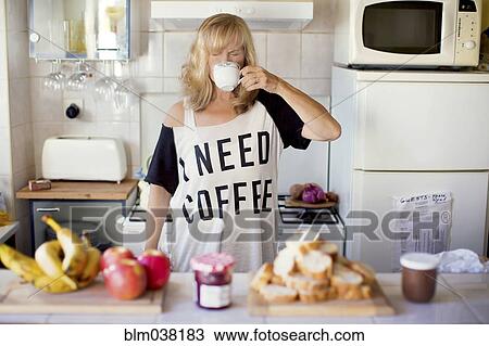 Caucasian woman drinking coffee in kitchen View Large Photo Image Stock Image - Caucasian woman drinking coffee in kitchen. Fotosearch
