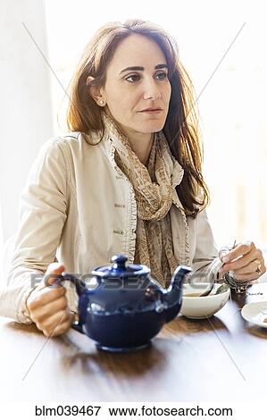Caucasian woman drinking tea at table View Large Photo Image Stock Photo - Caucasian woman drinking tea at table. Fotosearch