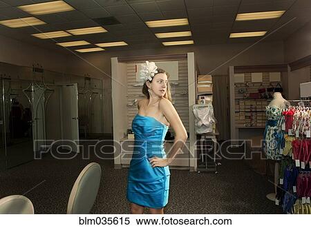 Stock Photography - Caucasian woman examining formal gown in store. Fotosearch