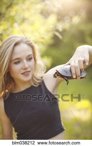 Caucasian woman examining turtle in forest View Large Photo Image Stock Image - Caucasian woman examining turtle in forest. Fotosearch