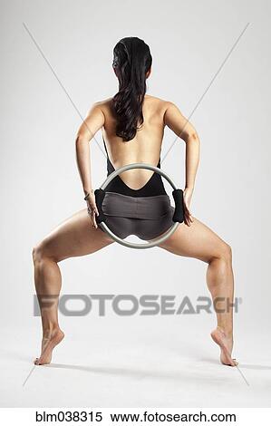 Stock Photography - Caucasian woman exercising with resistance ring. Fotosearch