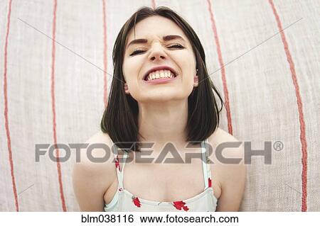 Stock Photograph - Caucasian woman grinning with bared teeth. Fotosearch