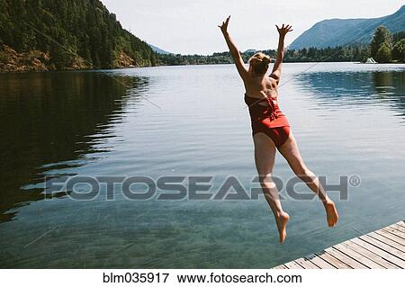 Caucasian woman jumping from dock into rural lake View Large Photo Image Stock Photo - Caucasian woman jumping from dock into rural lake. Fotosearch