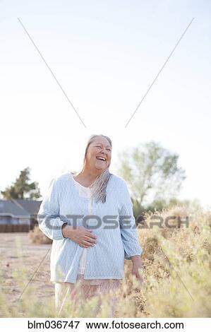 Stock Photo - Caucasian woman laughing in backyard. Fotosearch