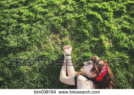 Caucasian woman laying in grass View Large Photo Image Picture - Caucasian woman laying in grass. Fotosearch