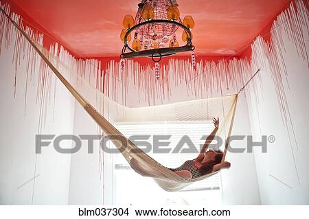 Caucasian woman laying in hammock under dripping ceiling View Large Photo Image Picture - Caucasian woman laying in hammock under dripping ceiling. Fotosearch