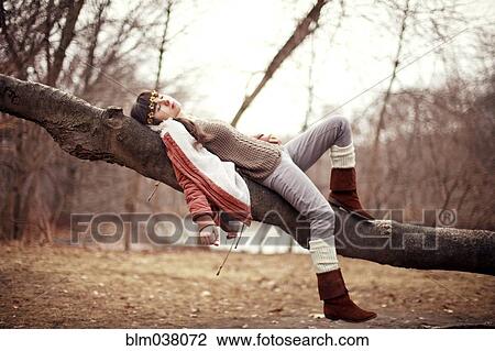Caucasian woman laying in tree in rural field View Large Photo Image Stock Image - Caucasian woman laying in tree in rural field. Fotosearch